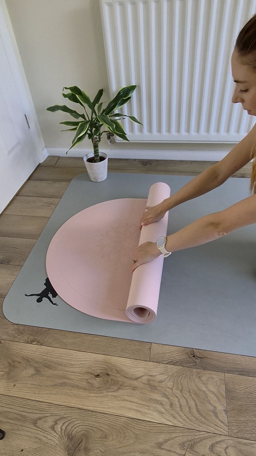 Rolling out a pink Pilates mat
